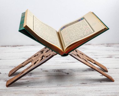 İstanbul, Türkiye - 11 Şubat 2022; Kutsal Kur 'an ve ibadet standı. Kur 'an-ı Kerim, caminin ahşap zemininde Müslümanların duaları, karanlık arka plan, mesajlar için boşluk.