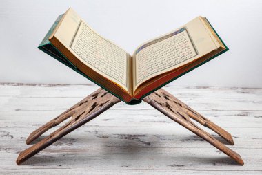 İstanbul, Türkiye - 11 Şubat 2022; Kutsal Kur 'an ve ibadet standı. Kur 'an-ı Kerim, caminin ahşap zemininde Müslümanların duaları, karanlık arka plan, mesajlar için boşluk.