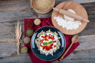 Mükemmel Türk Ravioli 'si ve tereyağında kızartılmış acı biber. Kırmızı biber, domates sosu, yoğurt ve naneli Türk mantı. Geleneksel Türk yemeği tabağı