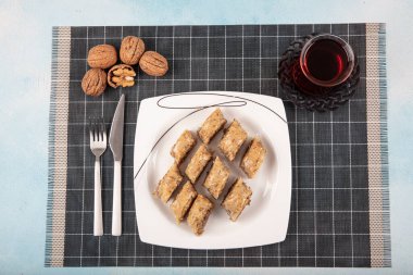 Geleneksel Türk tatlı cevizli baklava ve ahşap masa üzerinde çay. Yemek keki geçmişi. Geleneksel Ceviz Baklava tatlı ve çay konsepti.
