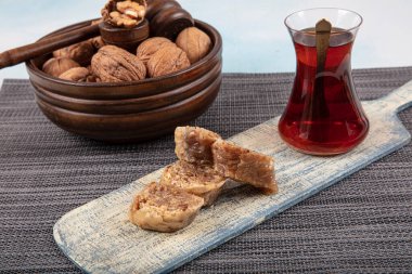 Geleneksel Türk tatlı cevizli baklava ve ahşap masa üzerinde çay. Yemek keki geçmişi. Geleneksel Ceviz Baklava tatlı ve çay konsepti.