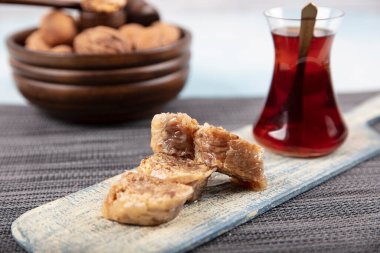 Geleneksel Türk tatlı cevizli baklava ve ahşap masa üzerinde çay. Yemek keki geçmişi. Geleneksel Ceviz Baklava tatlı ve çay konsepti.