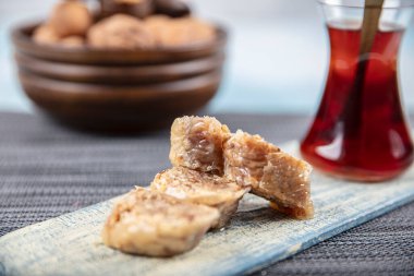 Geleneksel Türk tatlı cevizli baklava ve ahşap masa üzerinde çay. Yemek keki geçmişi. Geleneksel Ceviz Baklava tatlı ve çay konsepti.