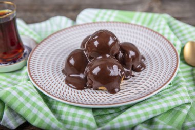 Çikolata ve tabakla nefis profiteroller. Krema ve çikolata kaplı lezzetli profiteroller. Ev yapımı profiterol choux çikolatalı ganache.