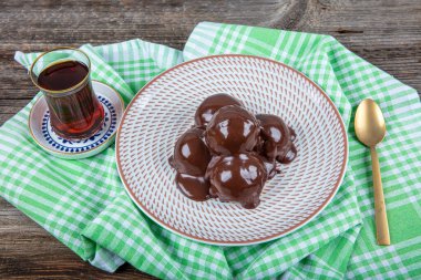 Çikolata ve tabakla nefis profiteroller. Krema ve çikolata kaplı lezzetli profiteroller. Ev yapımı profiterol choux çikolatalı ganache.