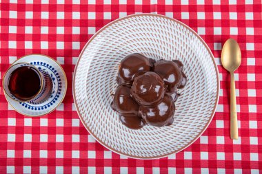 Çikolata ve tabakla nefis profiteroller. Krema ve çikolata kaplı lezzetli profiteroller. Ev yapımı profiterol choux çikolatalı ganache.