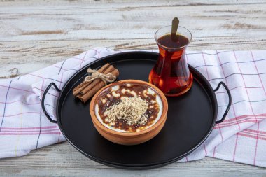 Tarçın çubukları ve fındıklı güveçte pişmiş sütlü sütlü sütlü sütlü tatlı. Tarçın ve Nutmeg 'li sütlaç. Sütlaç, kopyalama alanı