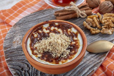 Tarçın çubukları ve fındıklı güveçte pişmiş sütlü sütlü sütlü sütlü tatlı. Tarçın ve Nutmeg 'li sütlaç. Sütlaç, kopyalama alanı
