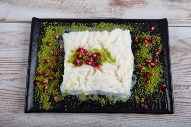 Geleneksel Türk Ramazan Tatlısı Gullac masada. Gullac, süt, gül suyu, ceviz, vanilya. Nar ve şam fıstığı ile süslenmiş. Osmanlı mutfağından tatlı