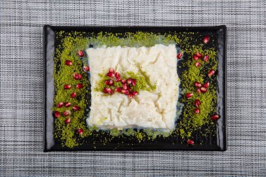 Geleneksel Türk Ramazan Tatlısı Gullac masada. Gullac, süt, gül suyu, ceviz, vanilya. Nar ve şam fıstığı ile süslenmiş. Osmanlı mutfağından tatlı