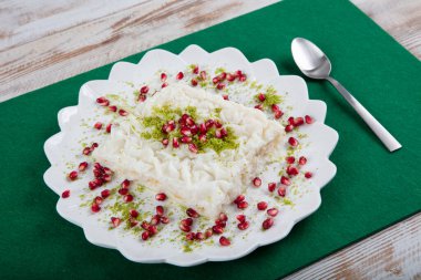 Geleneksel Türk Ramazan Tatlısı Gullac masada. Gullac, süt, gül suyu, ceviz, vanilya. Nar ve şam fıstığı ile süslenmiş. Osmanlı mutfağından tatlı