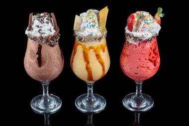 Üç bardak çeşitli aromalı milkshake. Çikolata, ananas ve çilekli milkshake..