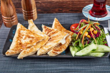 Gozme Türk çöreğidir. Tahta tahtada beyaz peynir ve Türk çayı ile taze pişmiş Türk tortillası Gözleme. Mesaj için yer var. El yapımı Türk geleneksel pastaları