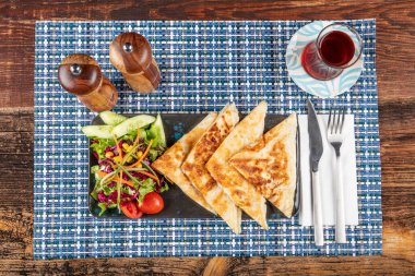 Gozme Türk çöreğidir. Tahta tahtada beyaz peynir ve Türk çayı ile taze pişmiş Türk tortillası Gözleme. Mesaj için yer var. El yapımı Türk geleneksel pastaları