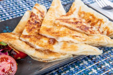 Gozme Türk çöreğidir. Tahta tahtada beyaz peynir ve Türk çayı ile taze pişmiş Türk tortillası Gözleme. Mesaj için yer var. El yapımı Türk geleneksel pastaları
