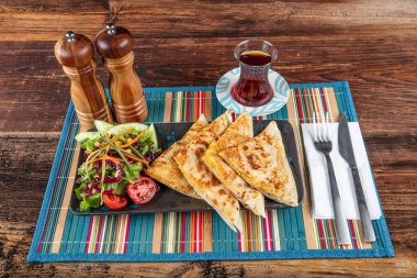 Gozme Türk çöreğidir. Tahta tahtada beyaz peynir ve Türk çayı ile taze pişmiş Türk tortillası Gözleme. Mesaj için yer var. El yapımı Türk geleneksel pastaları