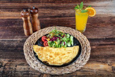 Çeri domatesli omlet fotoğrafı, maydanoz. Ve yukarıdan rendelenmiş peynirle sade ahşap bir doku ve metin için bir yer..