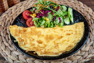 Çeri domatesli omlet fotoğrafı, maydanoz. Ve yukarıdan rendelenmiş peynirle sade ahşap bir doku ve metin için bir yer..