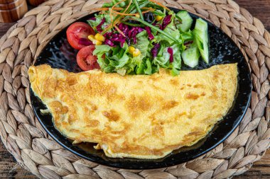 Çeri domatesli omlet fotoğrafı, maydanoz. Ve yukarıdan rendelenmiş peynirle sade ahşap bir doku ve metin için bir yer..