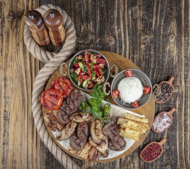 Türk mutfağı, karışık kebap. Kömürde kızartılmış et tabağı ve ahşap bir tahtada baharatlar. Et için kuzu, kuzu, kebap, tavuk, mantar ve domates sosu..
