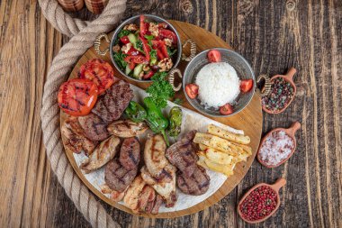 Türk mutfağı, karışık kebap. Kömürde kızartılmış et tabağı ve ahşap bir tahtada baharatlar. Et için kuzu, kuzu, kebap, tavuk, mantar ve domates sosu..