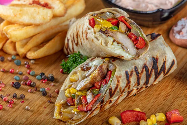 Turkish cuisine chicken wrap. Grilled chicken sandwich wrap with lettuce, red pepper and french fries.
