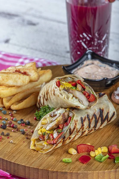 Turkish cuisine chicken wrap. Grilled chicken sandwich wrap with lettuce, red pepper and french fries.