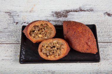 Beyaz ahşap arka planda Kibbeh. Kibbeh, Orta Doğu mutfağında popüler bir yemektir. Doldurulmuş köfteler, falafel, icli Kofta, Quibe. Üst Manzara. Metin için boş alan. Boşluğu kopyala
