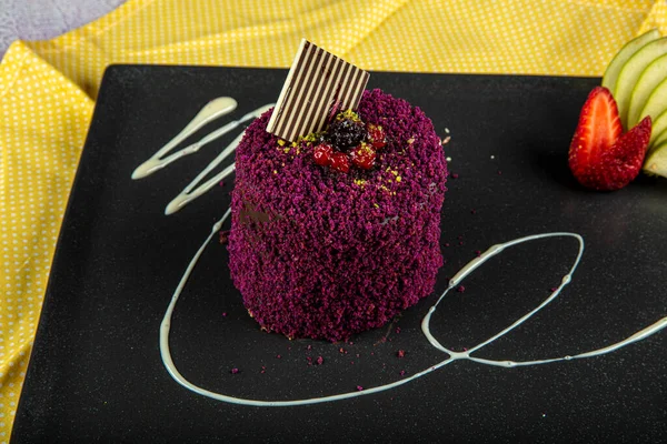 Glazed chocolate cake, one piece, with golden cake on a black plate on a dark black background. One piece cake.