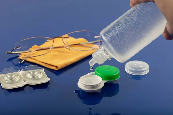 Eye glasses and contact lenses. Glasses, containers and contact lenses, isolated on blue background.