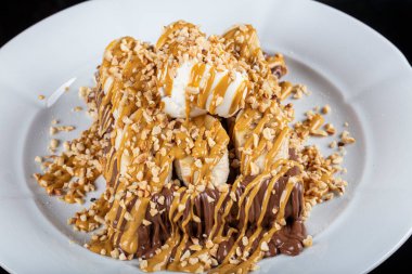 Belgian waffle with white chocolate. Croissant Waffle or Croffle with chocolate topping served in plate and black background. 