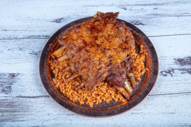 Lamb ribs on bulgur pilaf. Stuffed Ribs isolated on black background. Turkish name; 