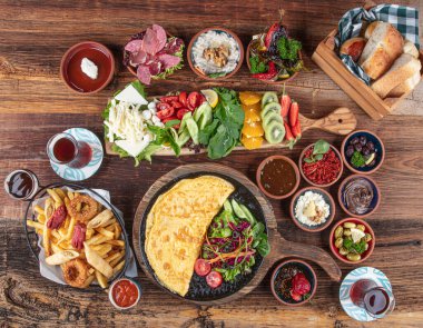 Traditional Turkish Breakfast served with traditional turkish tea on wood table. Breakfast or brunch table filled with all sorts of delicious delicatessen. Turkish name; Serpme Kahvalti.