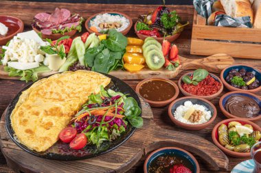Traditional Turkish Breakfast served with traditional turkish tea on wood table. Breakfast or brunch table filled with all sorts of delicious delicatessen. Turkish name; Serpme Kahvalti.