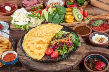 Traditional Turkish Breakfast served with traditional turkish tea on wood table. Breakfast or brunch table filled with all sorts of delicious delicatessen. Turkish name; Serpme Kahvalti.