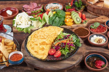 Traditional Turkish Breakfast served with traditional turkish tea on wood table. Breakfast or brunch table filled with all sorts of delicious delicatessen. Turkish name; Serpme Kahvalti.