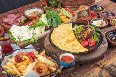 Traditional Turkish Breakfast served with traditional turkish tea on wood table. Breakfast or brunch table filled with all sorts of delicious delicatessen. Turkish name; Serpme Kahvalti.