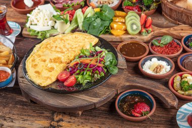 Traditional Turkish Breakfast served with traditional turkish tea on wood table. Breakfast or brunch table filled with all sorts of delicious delicatessen. Turkish name; Serpme Kahvalti.
