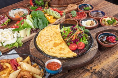 Traditional Turkish Breakfast served with traditional turkish tea on wood table. Breakfast or brunch table filled with all sorts of delicious delicatessen. Turkish name; Serpme Kahvalti.