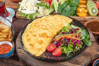 Traditional Turkish Breakfast served with traditional turkish tea on wood table. Breakfast or brunch table filled with all sorts of delicious delicatessen. Turkish name; Serpme Kahvalti.