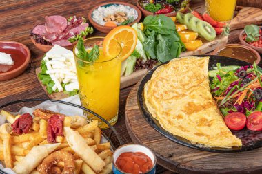 Traditional Turkish Breakfast served with traditional turkish tea on wood table. Breakfast or brunch table filled with all sorts of delicious delicatessen. Turkish name; Serpme Kahvalti.