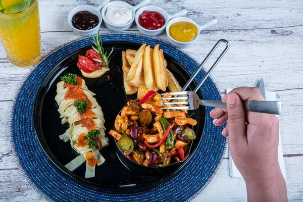 Fried Chicken with Hot Pepper Sauce. The appetizer is served with roasted or fried chicken, peppers, pasta and potatoes. Roasted chicken garnished with parsley. Food concept.