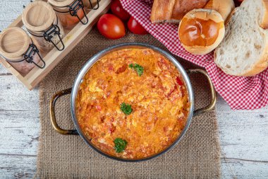 Famous Turkish menemen dinner on table, made by eggs, pepper and tomatoes. Traditional turkish food menemen made by eggs and tomatoes, tea concept background.