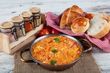 Famous Turkish menemen dinner on table, made by eggs, pepper and tomatoes. Traditional turkish food menemen made by eggs and tomatoes, tea concept background.