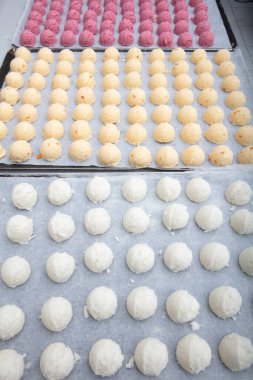 Cakes on automatic conveyor belt or line, baking process in confectionery factory. Food industry, cookie production.