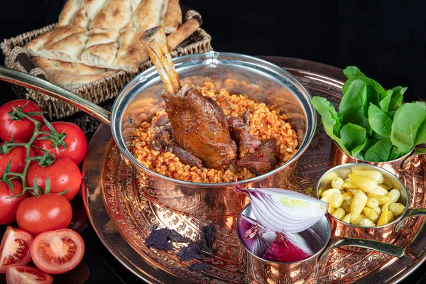 Traditional Turkish Food Lamb shank and rice. Slow cooked lamb shank. Lamb shank served on a Copper tray and in a Copper bowl.