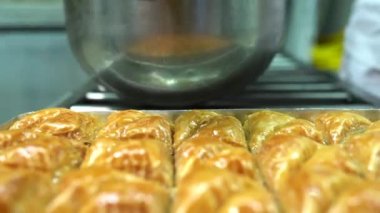 Baklava 'nın üzerine şurup döküyorum. Türk Baklava 'sına yeşil şam fıstıklı tatlı, katmanlı pastalı tatlı, doğranmış fındıkla dolu, şurup veya balla tatlandırılmış.