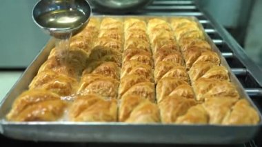 Baklava 'nın üzerine şurup döküyorum. Türk Baklava 'sına yeşil şam fıstıklı tatlı, katmanlı pastalı tatlı, doğranmış fındıkla dolu, şurup veya balla tatlandırılmış.