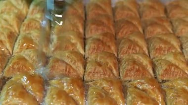 Baklava 'nın üzerine şurup döküyorum. Türk Baklava 'sına yeşil şam fıstıklı tatlı, katmanlı pastalı tatlı, doğranmış fındıkla dolu, şurup veya balla tatlandırılmış.