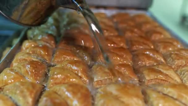 把糖浆倒在面包片上用绿色开心果把甜糖浆倒在土耳其面包片上 用分层糕点甜点 用切碎的坚果 用糖浆或蜂蜜加甜 — 图库视频影像